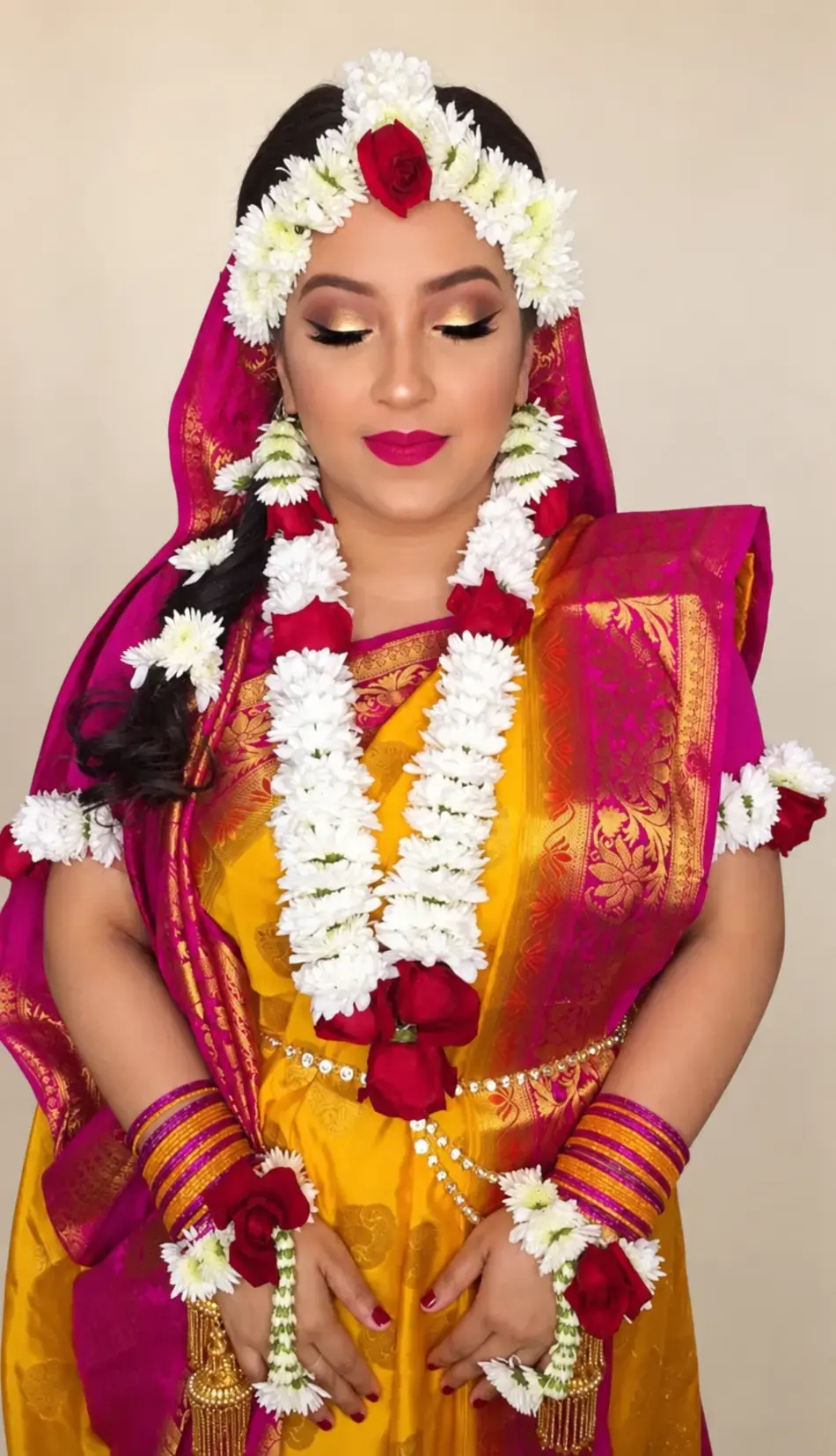 Bride wearing a red rose and white guldavri floral jewellery set with matching headpiece, necklace, earrings and hand jewellery.